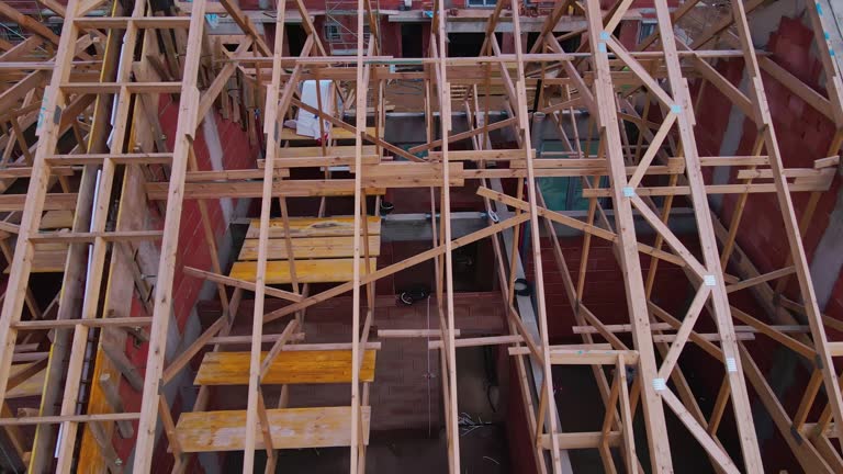 New house under construction, wooden truss system forming roof. Process of building project.